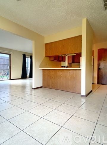 Oklahoma City house for rent - A kitchen with wooden cabinets and a white tile floor.