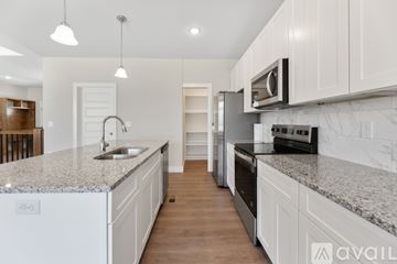 Park City house for rent - A kitchen with white cabinets and a marble countertop.