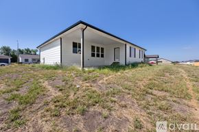 Park City house for rent - A small white house with a black roof is situated in a grassy field.