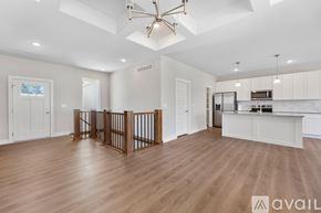 Park City house for rent - A spacious living room with a wooden floor and a staircase with a railing.