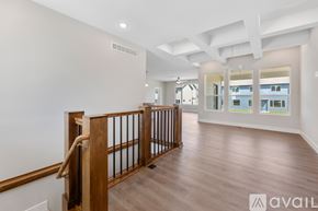 Park City house for rent - A spacious room with wooden flooring and a balcony with a railing.