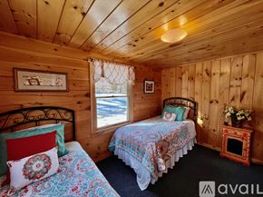 Campton house for rent - A cozy bedroom with two beds and a fireplace.
