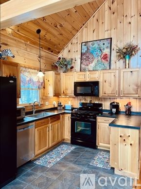 Campton house for rent - A kitchen with wooden cabinets and a black stove top oven.