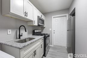 Baltimore apartment for rent - A kitchen with granite countertops and white cabinets.