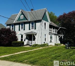 Lake George apartment for rent - A house with a green roof and white walls with a porch.