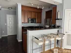 Alexandria condo for rent - A kitchen with a white counter and bar stools.