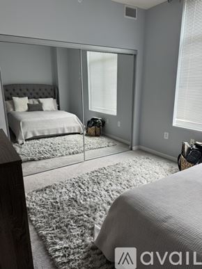 Alexandria condo for rent - A bedroom with a large bed and a mirror on the wall.