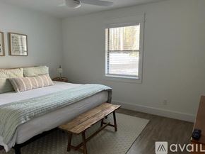 Santa Rosa Beach house for rent - A bedroom with a bed, a bench, and a window.
