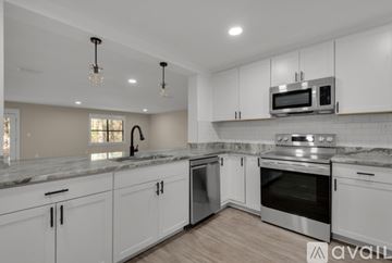 Santa Rosa Beach house for rent - A kitchen with white cabinets and a granite countertop.