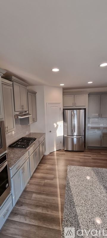 Cumming house for rent - A kitchen with wooden floors and granite countertops.