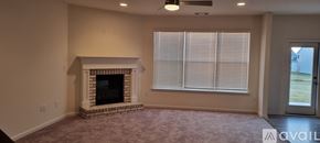 Cumming house for rent - A living room with a fireplace and a window with blinds.