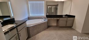 Cumming house for rent - A bathroom with a tub, sink, and mirror.