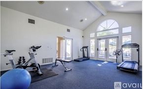 Calabasas apartment for rent - A well-equipped home gym with a variety of exercise machines and a blue exercise ball.