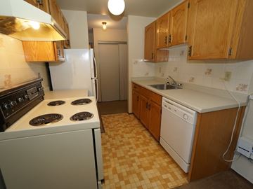 Wainwright apartment for rent - A kitchen with a white stove and a white dishwasher.