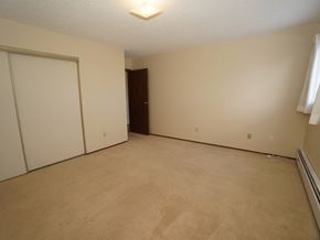 Wainwright apartment for rent - A room with a carpeted floor and a white door.