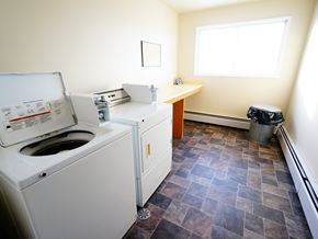 Wainwright apartment for rent - A white washing machine is in a room with a tiled floor and a window.