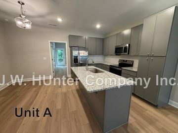 Wilson apartment for rent - A kitchen with wooden floors and a white ceiling.