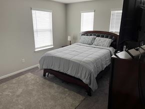 Houston house for rent - A bedroom with a bed, a lamp, and a TV.