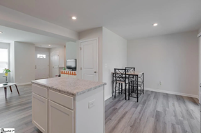 Greenville house for rent - A kitchen with a granite countertop and a dining table with chairs.