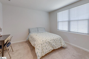 Greenville house for rent - A bedroom with a bed, a chair, and a table.