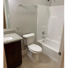 New Orleans apartment for rent - A white toilet sits next to a white bathtub in a bathroom.