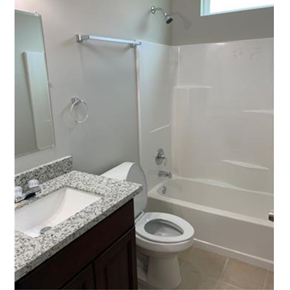 New Orleans apartment for rent - A white toilet is next to a white bathtub in a bathroom.