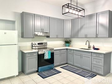 Pearl City house for rent - A kitchen with grey cabinets and a white fridge.