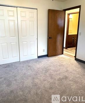 Fairfax apartment for rent - A room with a carpeted floor, two white doors, and one wooden door.