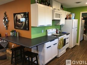 Lubbock house for rent - A kitchen with white cabinets and a black countertop.