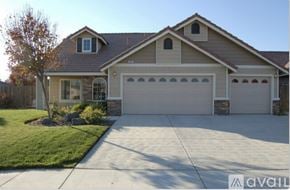 Lemoore house for rent - A house with a garage and a tree in front of it.
