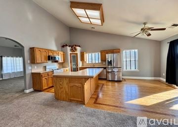 Lemoore house for rent - A kitchen with wooden cabinets and a white fridge.