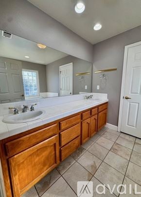Lemoore house for rent - A bathroom with a double sink vanity and a large mirror.
