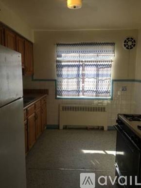 Cincinnati apartment for rent - A kitchen with a refrigerator, stove, and a window with blinds.