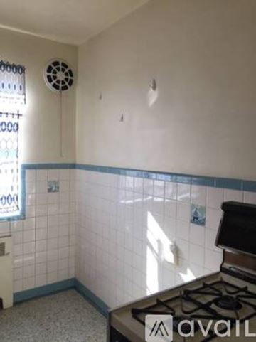 Cincinnati apartment for rent - A kitchen with a gas stove and a window with a fan.