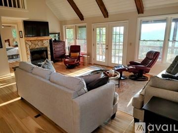 Scaly Mountain house for rent - A living room with a grey couch and a fireplace.
