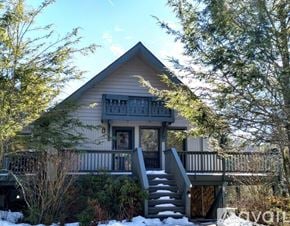 Sky Valley apartment for rent - A house with a grey roof and a balcony surrounded by trees.