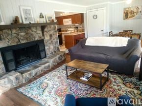 Sky Valley apartment for rent - A living room with a stone fireplace and a grey couch.