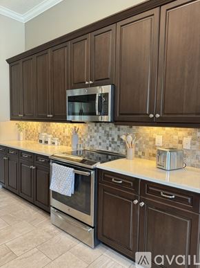 Venice house for rent - A kitchen with brown cabinets and a stainless steel oven.