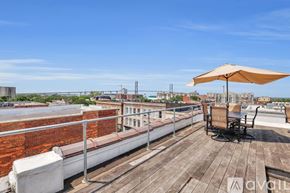 Savannah apartment for rent - A wooden deck with a white couch and a sun umbrella.