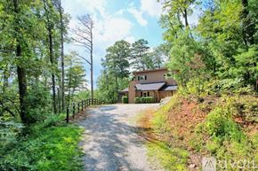 Clayton house for rent - A house is situated on a hill with a gravel road leading to it.