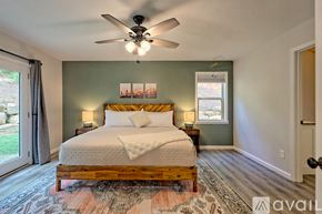 Clayton house for rent - A bedroom with a large bed and a ceiling fan.