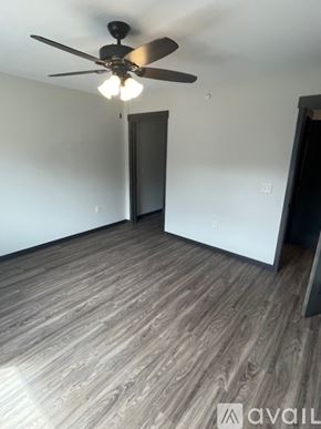 Altoona apartment for rent - A room with a ceiling fan and wooden flooring.