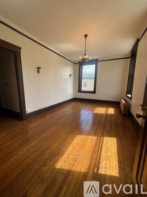 Oswego apartment for rent - A room with wooden floors and a chandelier.