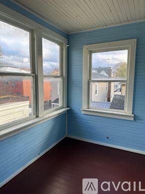 Oswego apartment for rent - A room with blue walls and a window overlooking a street.