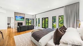 , Beverly Hills house for rent - A modern bedroom with a large bed and a fireplace.