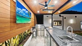 , Beverly Hills house for rent - A modern kitchen with a wooden wall and a ceiling fan.