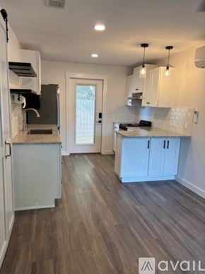 Blanco apartment for rent - A kitchen with white cabinets and a marble countertop.