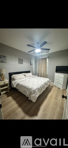 Houston townhouse for rent - A bedroom with a bed, dresser, and ceiling fan.