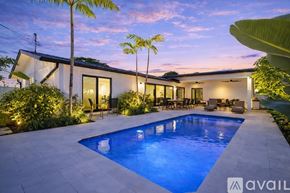 Lighthouse Point house for rent - A pool surrounded by green plants at night.