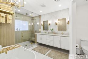 Lighthouse Point house for rent - A modern kitchen with white cabinets and a marble island.